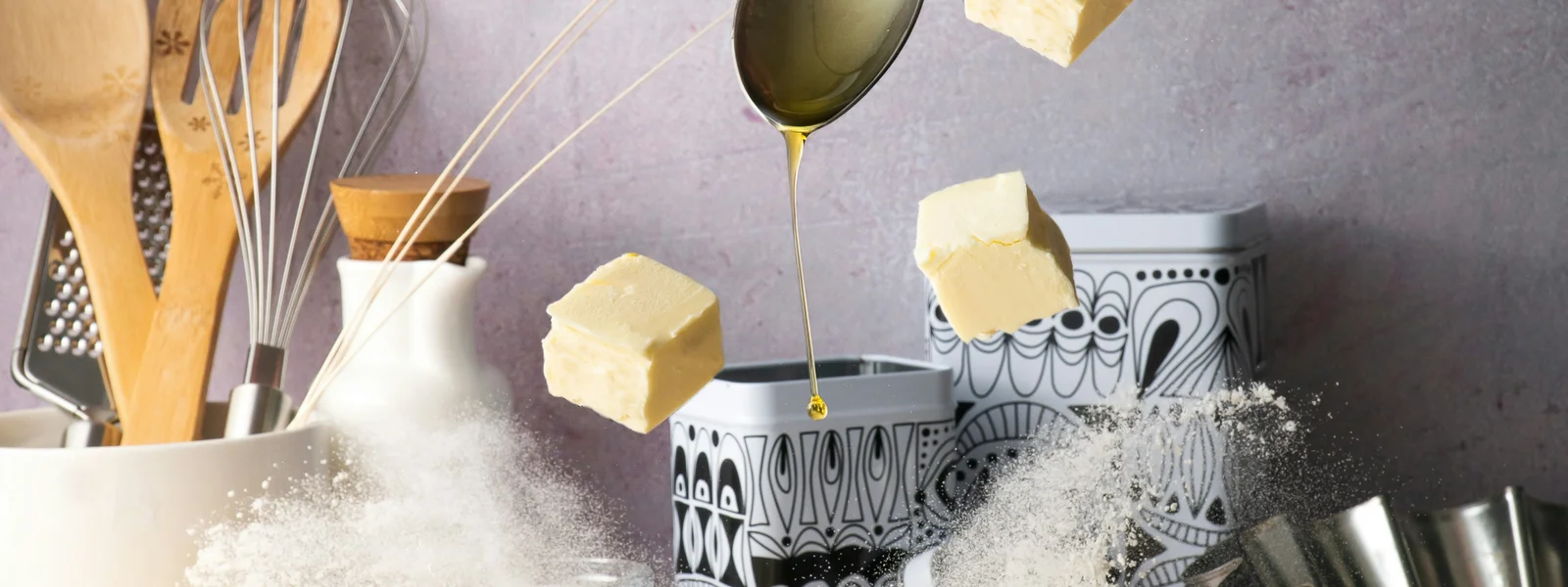 Gourmet baking ingredients exploding in motion with falling butter and flying flour